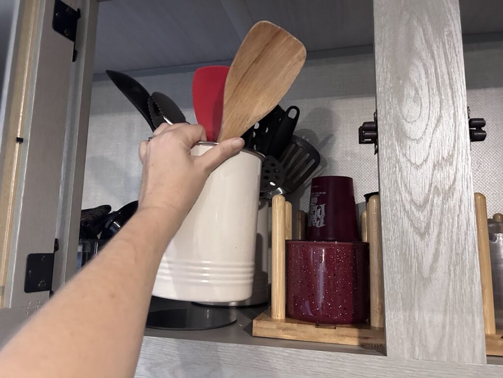 Hand grabbing magnetic cooking utensil holder