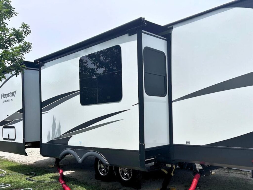 Side of trailer trailer RV with awnings over slide-outs.