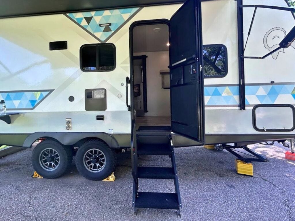 RV with door open showing RV screen door bar installed.