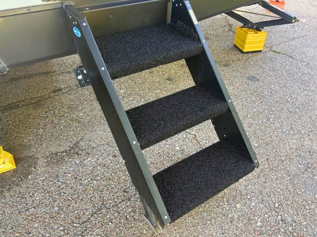 RV steps covered with black rugs.