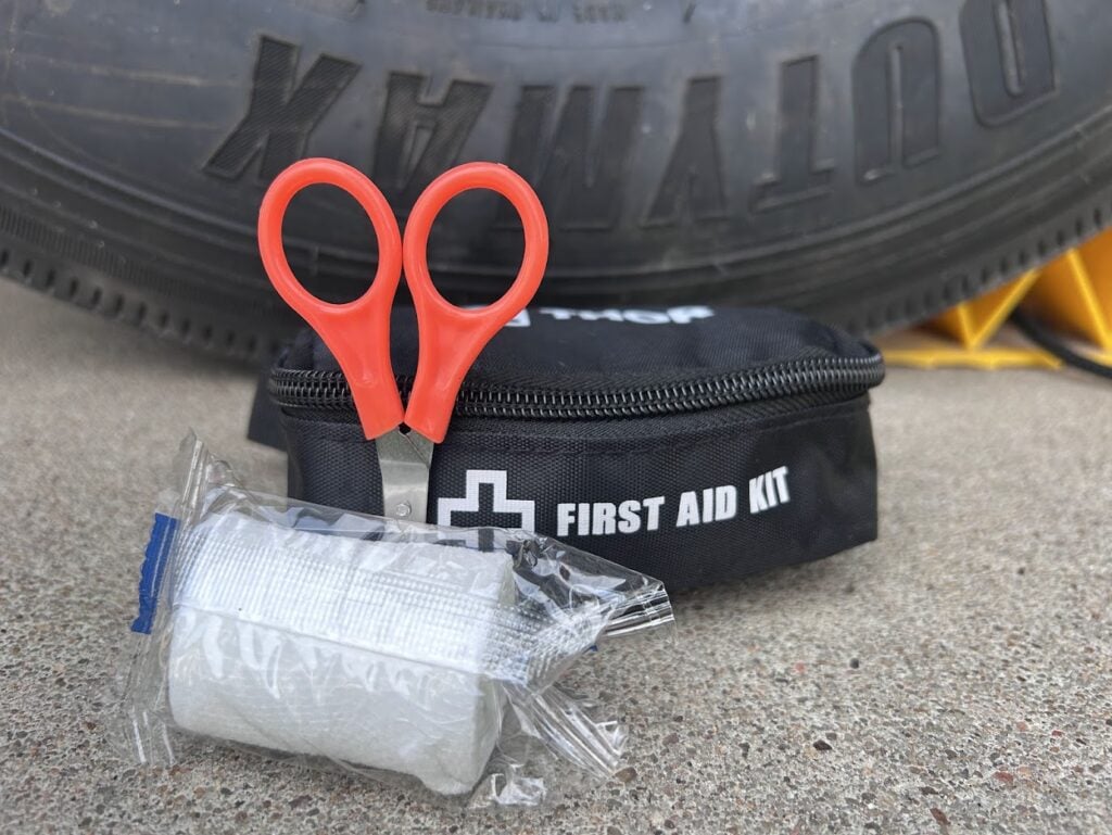 First aid kit sitting in front of RV tire.