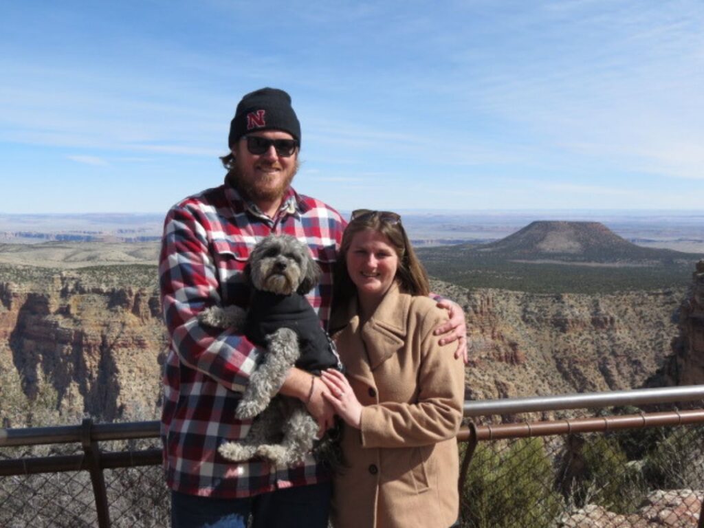 Couple with dog posing at rim of Grand Canyon