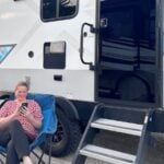 Woman using smartphone at RV campsite