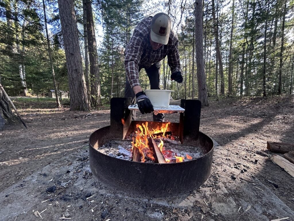 man cooking over campfire