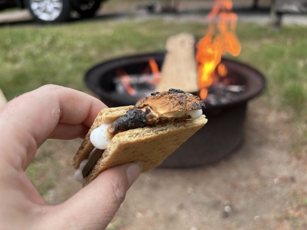 Smore in woman's hand by campfire