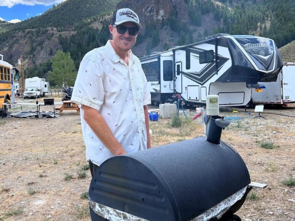 man grilling on smoker at RV park