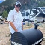man grilling on smoker at RV park