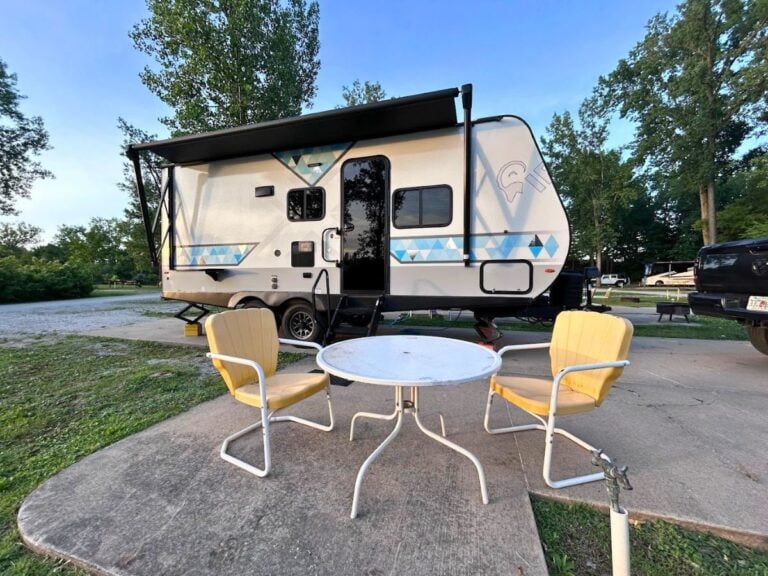 Travel trailer RV at campsite with yellow chairs